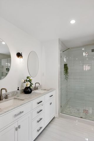 2423 Chicago Blvd, Detroit, MI 48206 - bathroom featuring double vanity, a shower stall, and a sink