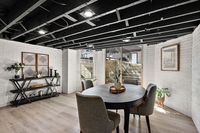 2423 Chicago Blvd, Detroit, MI 48206 - dining space featuring wood finished floors and brick wall
