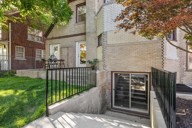 2423 Chicago Blvd, Detroit, MI 48206 - doorway to property with brick siding, fence, and a yard