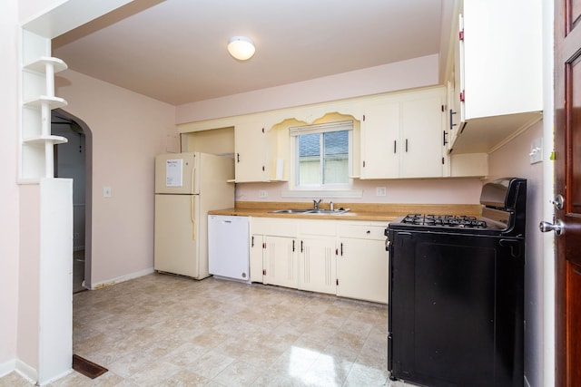 kitchen featuring white appliances, baseboards, light countertops, white cabinets, and a sink