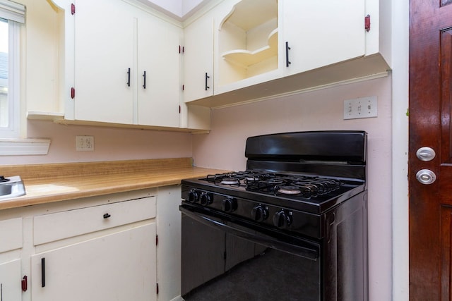 kitchen featuring gas stove, light countertops, open shelves, and white cabinetry