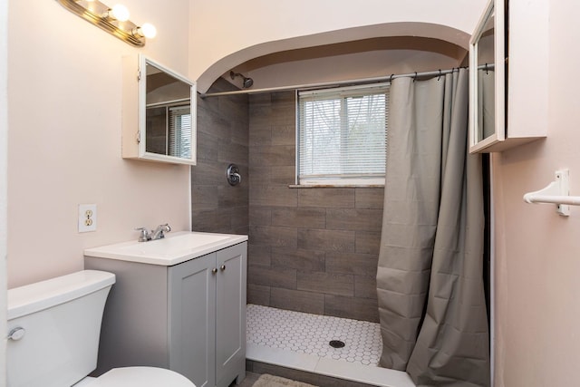 full bath with vanity, toilet, and tiled shower