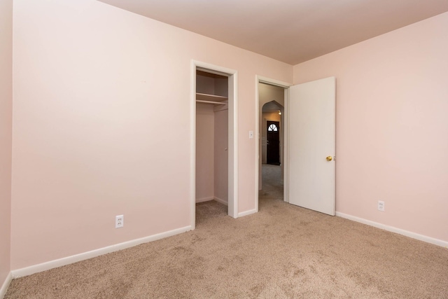 unfurnished bedroom featuring baseboards, carpet, and a closet