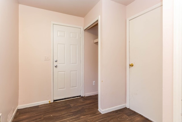 interior space with baseboards, dark wood-style flooring, and visible vents