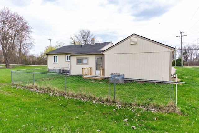 back of house with a lawn, central AC unit, fence, and a chimney