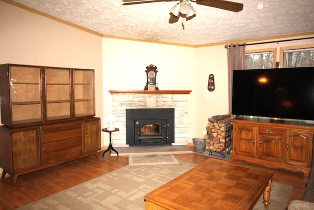 living area featuring ornamental molding, a textured ceiling, ceiling fan, and wood finished floors