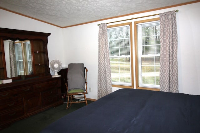 bedroom with a textured ceiling, crown molding, and baseboards