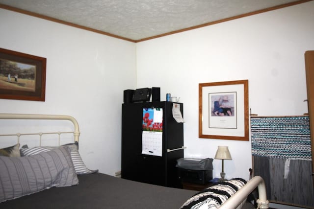bedroom with a textured ceiling and crown molding
