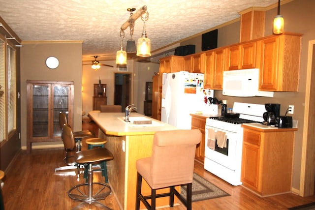 kitchen featuring crown molding, a sink, ceiling fan, dark wood-style flooring, and white appliances