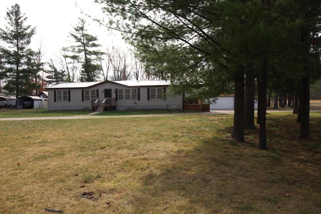 manufactured / mobile home featuring metal roof, a front lawn, and a garage