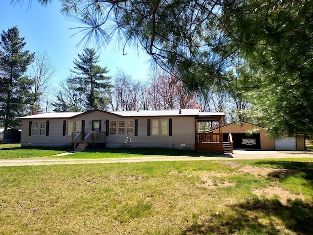 8458 S Broadway, Idlewild, MI 49642 - manufactured / mobile home featuring crawl space, a front yard, an outbuilding, a carport, and metal roof