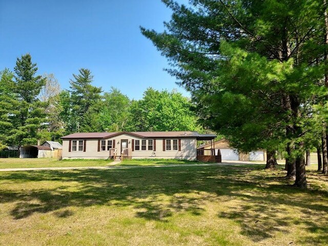 8458 S Broadway, Idlewild, MI 49642 - ranch-style home with a front lawn, an outbuilding, and a garage