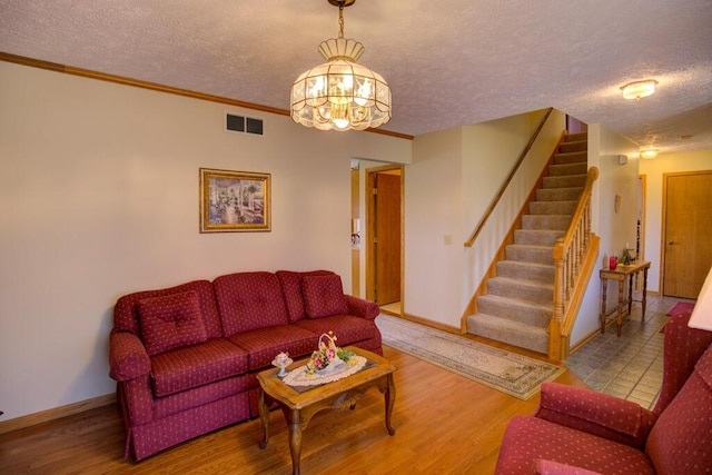 1414 Plains Rd, Leslie, MI 49251 - living area with visible vents, an inviting chandelier, a textured ceiling, and stairway