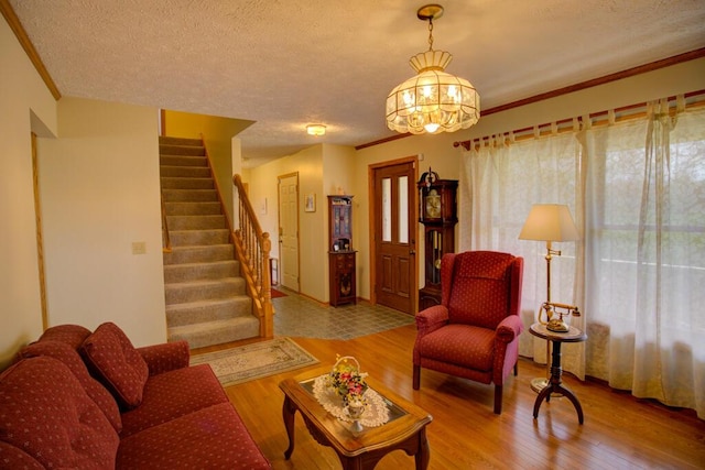1414 Plains Rd, Leslie, MI 49251 - living room with wood finished floors, an inviting chandelier, stairs, and a textured ceiling