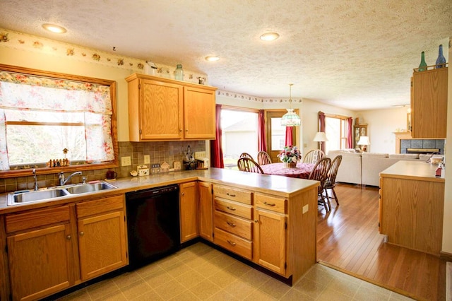 1414 Plains Rd, Leslie, MI 49251 - kitchen with a sink, decorative backsplash, black dishwasher, a peninsula, and light countertops