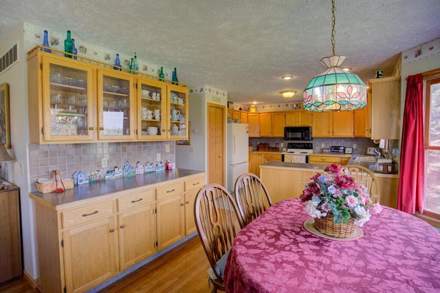 1414 Plains Rd, Leslie, MI 49251 - dining area featuring light wood finished floors, a textured ceiling, and visible vents