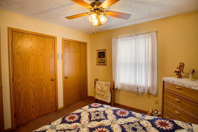 1414 Plains Rd, Leslie, MI 49251 - carpeted bedroom featuring a textured ceiling, two closets, and a ceiling fan