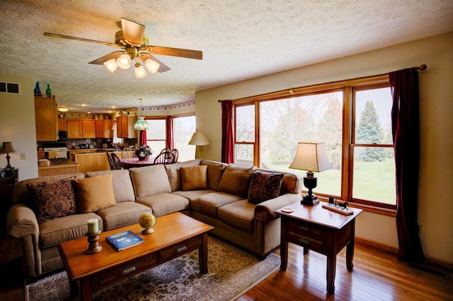 1414 Plains Rd, Leslie, MI 49251 - living area with a textured ceiling, a ceiling fan, and plenty of natural light