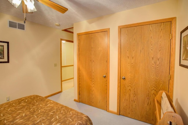 1414 Plains Rd, Leslie, MI 49251 - bedroom featuring two closets, carpet flooring, visible vents, a ceiling fan, and a textured ceiling