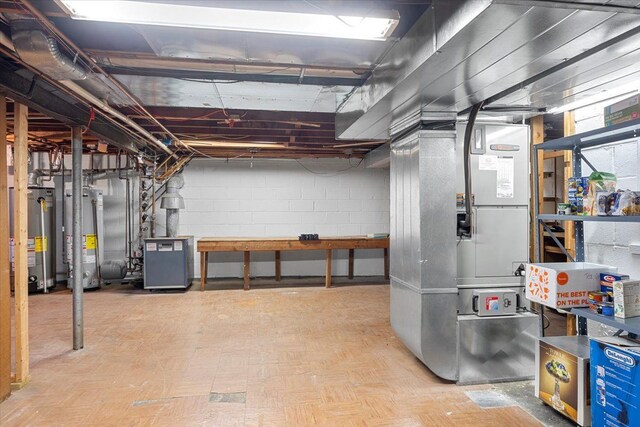 unfinished below grade area featuring a heating unit, concrete block wall, heating unit, and gas water heater