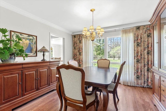 dining space with an inviting chandelier, light wood-type flooring, and crown molding