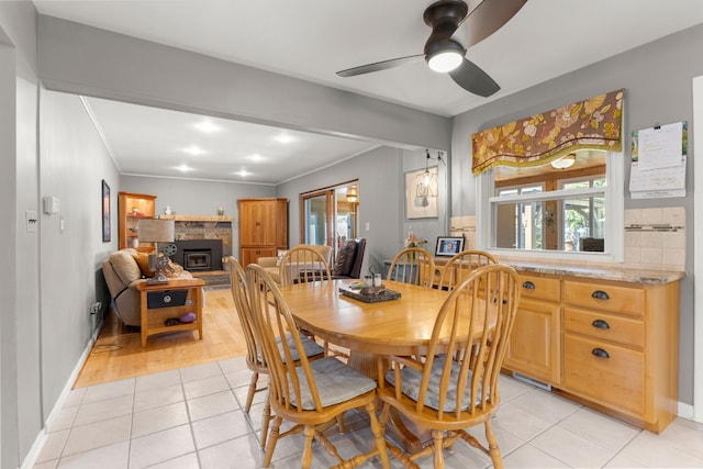 dining room with ceiling fan, light tile patterned flooring, crown molding, and plenty of natural light