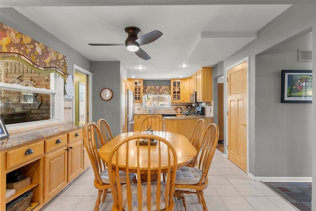 dining room with light tile patterned flooring, ceiling fan, visible vents, and baseboards