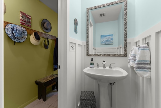 bathroom featuring a sink, tile patterned flooring, visible vents, and baseboards