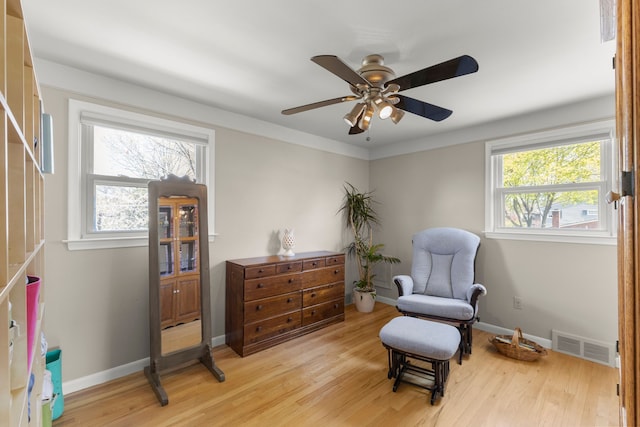 living area with light wood finished floors, visible vents, and a healthy amount of sunlight