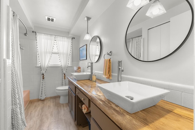 full bathroom featuring tile walls, visible vents, toilet, and a sink