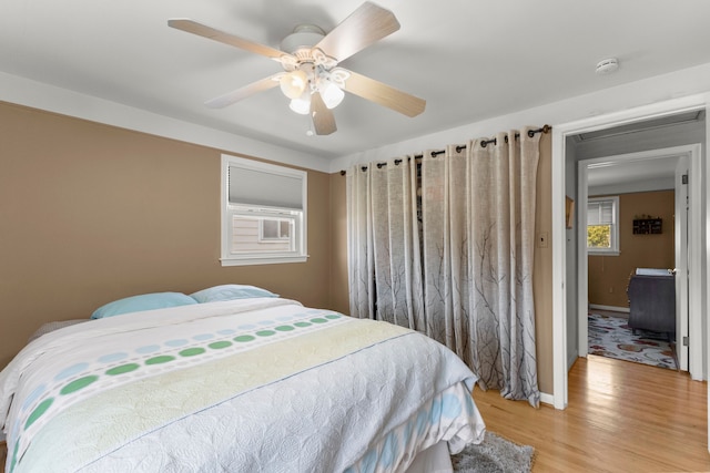 bedroom featuring baseboards, ceiling fan, and light wood-style flooring