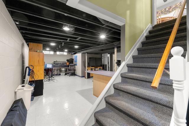 stairway featuring concrete block wall and tile patterned floors