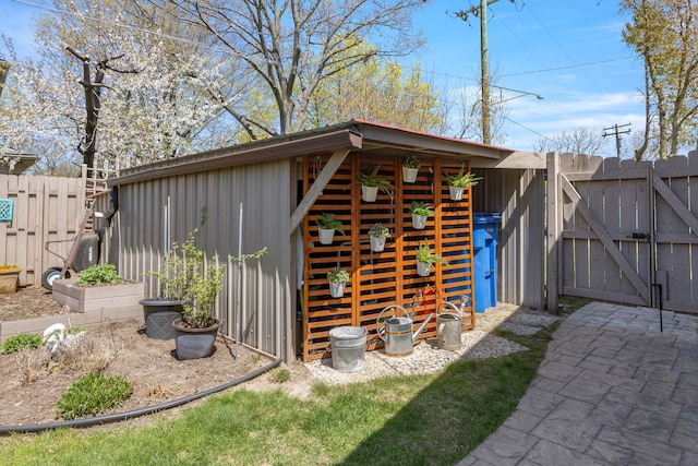 view of outdoor structure with a gate, fence, and an outdoor structure