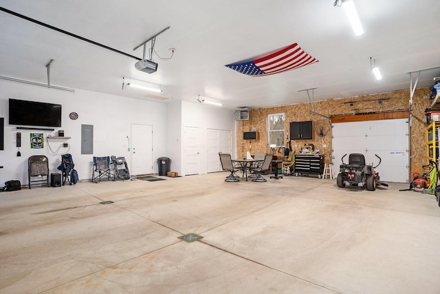 garage with a garage door opener and electric panel