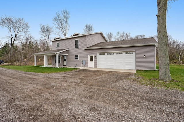back of property featuring a porch, a lawn, dirt driveway, and an attached garage