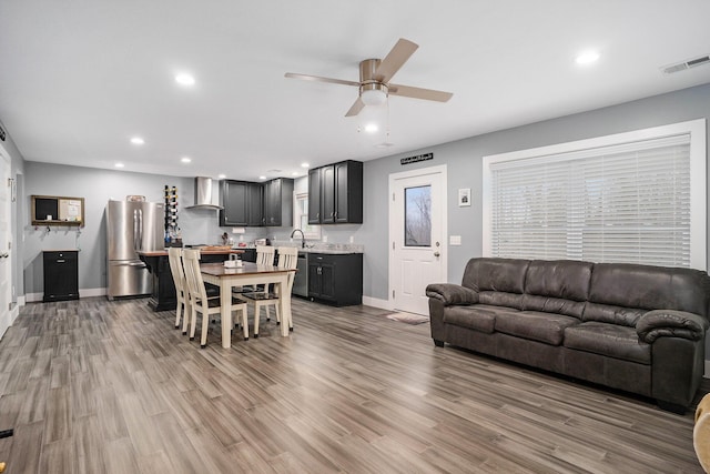 living room with wood finished floors, ceiling fan, recessed lighting, and baseboards