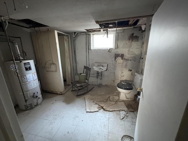 below grade area with gas water heater and a sink