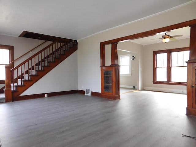 unfurnished living room featuring ceiling fan, stairs, visible vents, baseboards, and wood finished floors