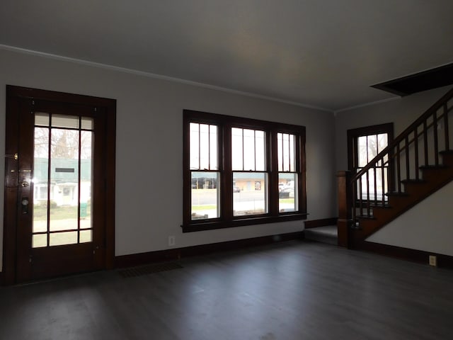 unfurnished living room featuring crown molding, wood finished floors, and plenty of natural light