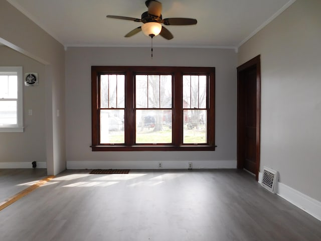 empty room featuring wood finished floors, visible vents, and a ceiling fan