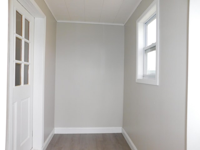 unfurnished room with baseboards, wood finished floors, and crown molding