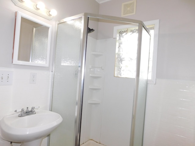 bathroom with visible vents, a shower stall, and a sink