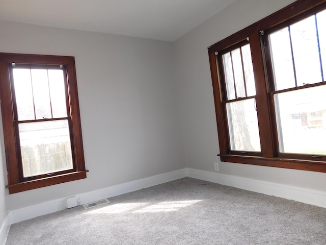 carpeted empty room with visible vents and baseboards