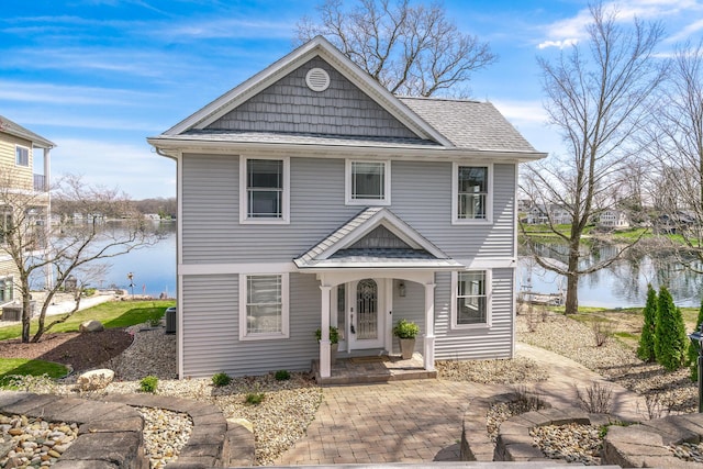 1300 N Eagle Lake Dr, Kalamazoo, MI 49009 - view of front of home with a shingled roof, cooling unit, and a water view