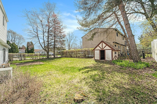 view of yard featuring an outbuilding, a shed, and fence