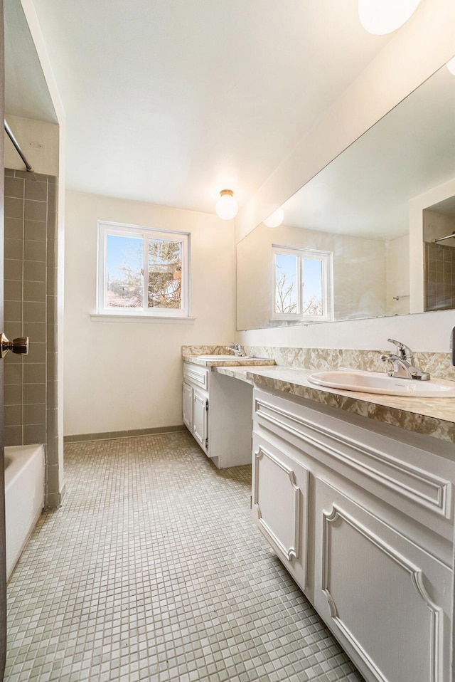 full bathroom featuring baseboards, tile patterned flooring, vanity, and plenty of natural light