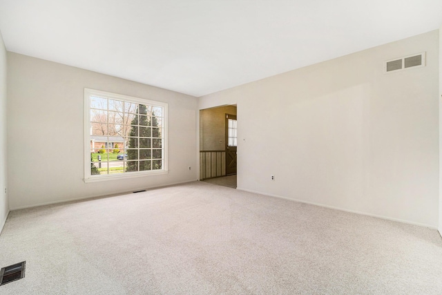 carpeted spare room with baseboards and visible vents