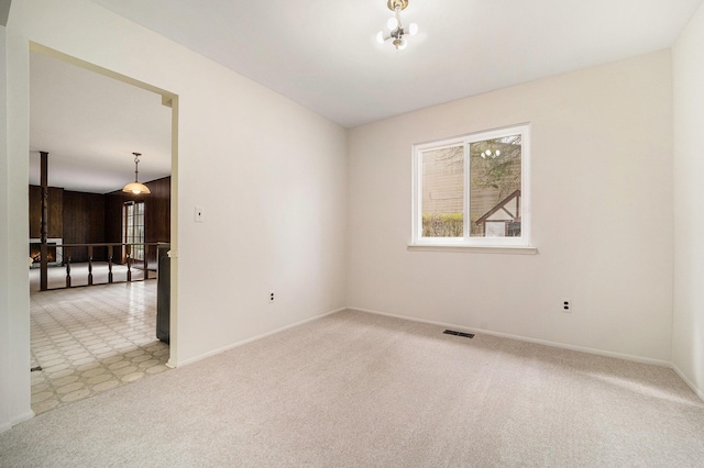 carpeted spare room featuring visible vents and baseboards
