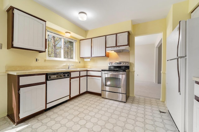 kitchen featuring light floors, white appliances, decorative backsplash, under cabinet range hood, and light countertops