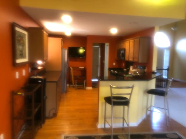 1130 Andover Cir, Commerce Twp, MI 48390 - kitchen featuring a peninsula, dark countertops, a kitchen bar, light wood-style floors, and recessed lighting